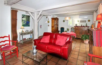 a living room with a red couch and a table at Lovely Home In Cheval-Blanc in Cheval-Blanc