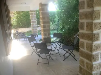 a patio with a table and chairs in a building at Le chant de la sorgue in LʼIsle-sur-la-Sorgue
