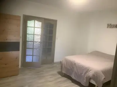 a bedroom with a bed and a sliding glass door at Le chant de la sorgue in LʼIsle-sur-la-Sorgue