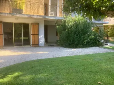 a building with a yard with a bush in front of it at Le chant de la sorgue in LʼIsle-sur-la-Sorgue