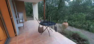 a patio with a table and chairs on a porch at Appartement climatisé sur golf de L'Isle-Sur-La-Sorgue in Saumane-de-Vaucluse