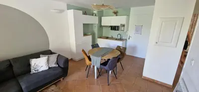 a living room with a couch and a table at Appartement climatisé sur golf de L'Isle-Sur-La-Sorgue in Saumane-de-Vaucluse