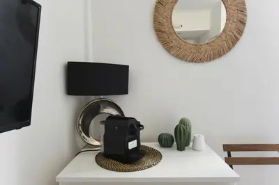 aazon echo sitting on a table in a living room with a mirror at Studio Garrigue in La Fare-les-Oliviers
