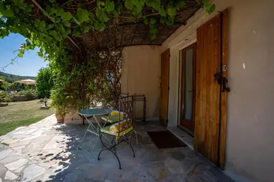 a patio with a table and chairs next to a door at Mon Ventoux - Cozyhotes in Sault-de-Vaucluse