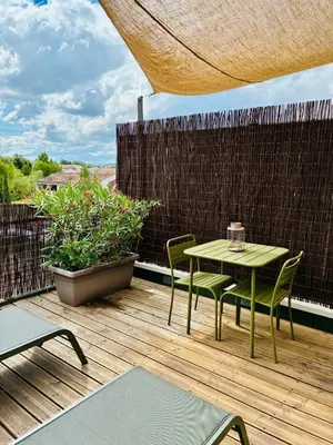 a patio with a table and chairs on a deck at Studio Nuitée en Provence 2 in Aix-en-Provence