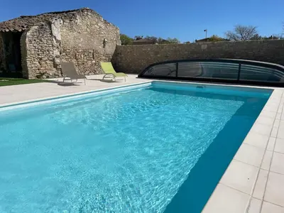 a swimming pool with a car parked next to a house at Clos du Cardinal avec piscine in LʼIsle-sur-la-Sorgue