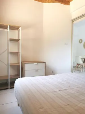 a bedroom with a bed and a book shelf at Charmant T2 avec extérieur au cœur du Vaucluse in Châteauneuf-de-Gadagne