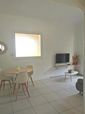 a living room with a table and a tv at Charmant T2 avec extérieur au cœur du Vaucluse in Châteauneuf-de-Gadagne