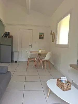 a living room with a table and chairs at Charmant T2 avec extérieur au cœur du Vaucluse in Châteauneuf-de-Gadagne