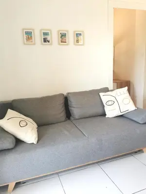 a couch in a living room with pillows on it at Charmant T2 avec extérieur au cœur du Vaucluse in Châteauneuf-de-Gadagne