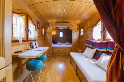 a room with a couch and a table in a train at Roulotte chez Manon en Luberon in Lagnes