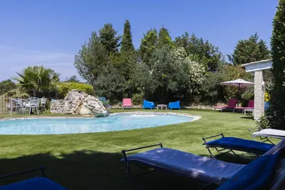 a swimming pool with chairs and tables in a yard at Roulotte chez Manon en Luberon in Lagnes
