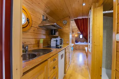 a kitchen in a log cabin with a sink at Roulotte chez Manon en Luberon in Lagnes
