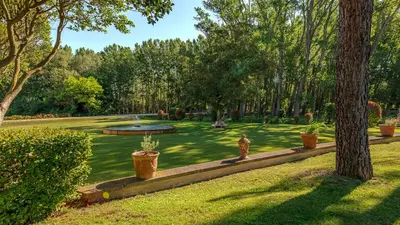 a garden with a fire hydrant and a pond at Chateau Talaud in Loriol-du-Comtat