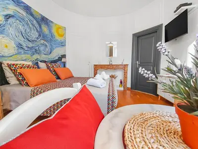 a living room with a couch and a painting at L'Isle d'Or - La Nuit Etoilée in LʼIsle-sur-la-Sorgue