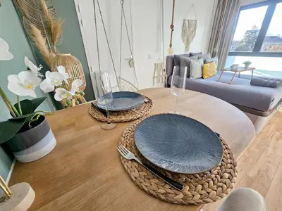 a living room with a table with two glasses and a couch at 107 Paisible et unique avec terrasse sur vue piscine in Éguilles