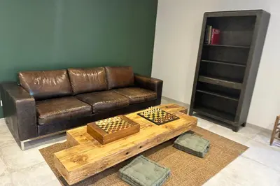 a living room with a leather couch and a coffee table at Mas Sylvie - Isle-sur-la-Sorgue in LʼIsle-sur-la-Sorgue