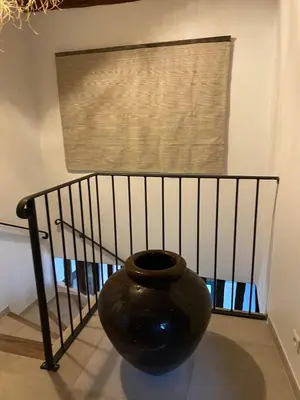 a large black vase sitting in front of a window at Mas Sylvie - Isle-sur-la-Sorgue in LʼIsle-sur-la-Sorgue