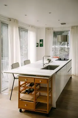 a kitchen with a sink and a counter with chairs at Beautiful house in the heart of its pine forest - private pool in Les Taillades