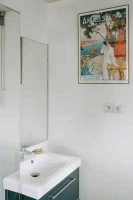 a bathroom with a sink and a poster on the wall at Beautiful house in the heart of its pine forest - private pool in Les Taillades