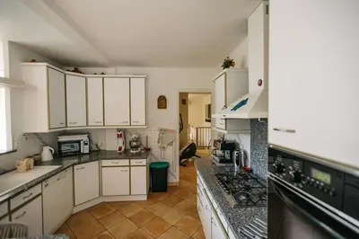 a kitchen with white cabinets and a stove top oven at Villa Balleti - private pool with a view in Apt
