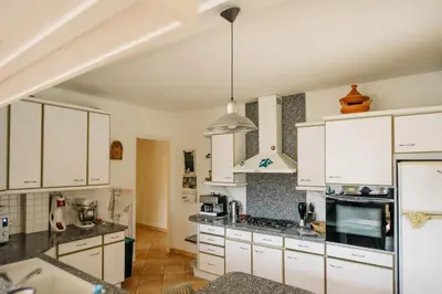 a kitchen with white cabinets and a stove top oven at Villa Balleti - private pool with a view in Apt