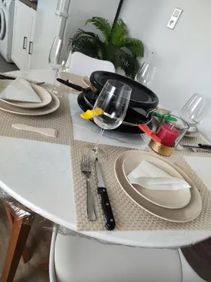 a kitchen with a table and chairs and a clock at Appartement de Charme L'Isle-sur-la-Sorgue sur la Sorgues in LʼIsle-sur-la-Sorgue
