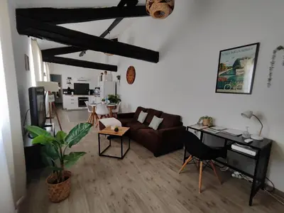 a living room with a couch and a piano at Appartement de Charme L'Isle-sur-la-Sorgue sur la Sorgues in LʼIsle-sur-la-Sorgue