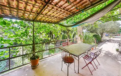 a screened in porch with a table and chairs at Gorgeous Home In Eyragues in Eyragues