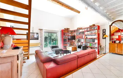 a living room with a red leather couch at Gorgeous Home In Eyragues in Eyragues