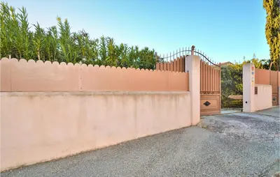 an orange fence with a gate and a driveway at Gorgeous Home In Eyragues in Eyragues