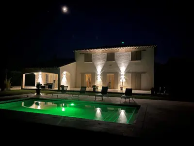 a house with a swimming pool at night at La Bastide Cezanne Natural elegance in Aix-en-Provence