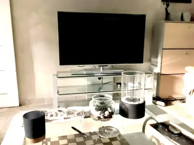 a living room with a tv and a table with a table sidx sidx at Appartement spacieux à Aix-en-Provence 100 m² avec hammam in Aix-en-Provence