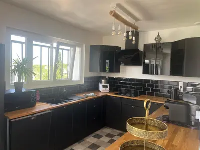 a kitchen with black cabinets and a counter top at Haut de villa avec piscine privée et extérieur in Lançon-Provence