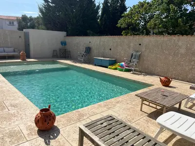 a swimming pool with a table and chairs and a table at Haut de villa avec piscine privée et extérieur in Lançon-Provence
