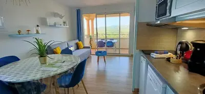 a kitchen and living room with a table and a couch at Appartement vue panoramique au domaine et golf de pont royal in Mallemort
