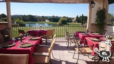 a patio with tables and chairs with red table cloth at Appartement vue panoramique au domaine et golf de pont royal in Mallemort