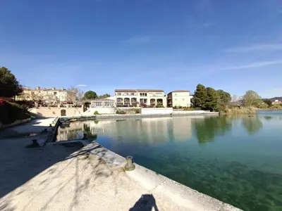 a large body of water with buildings in the background at Appartement vue panoramique au domaine et golf de pont royal in Mallemort