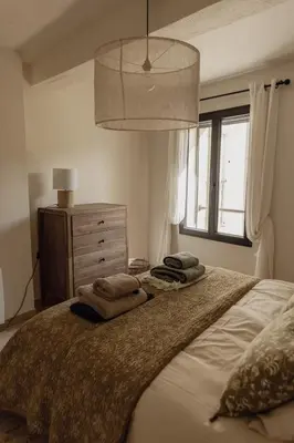 a bedroom with a large bed with pillows on it at L'Olivier in Mormoiron