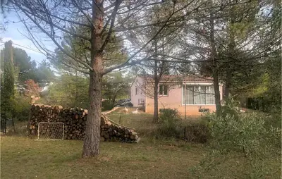 a pile of logs in a yard next to a house at 3 Bedroom Cozy Home In Meyrargues in Meyrargues