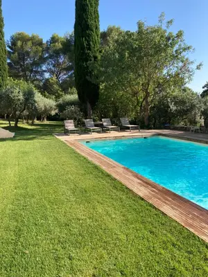 a swimming pool in a yard with chairs and trees at La Manuia in Ventabren