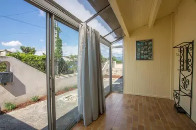an empty room with sliding glass doors and a staircase at La Villa des Sorgues in LʼIsle-sur-la-Sorgue