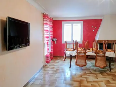 a dining room with tables and chairs and a flat screen tv at La Villa des Sorgues in LʼIsle-sur-la-Sorgue