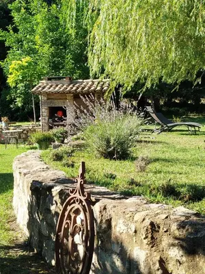 a metal object on a stone wall in a garden at Charmante bergerie dans un cadre bucolique in Saint-Rémy-de-Provence