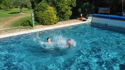a man swimming in a swimming pool at Le Mas des Perrines Maison d’Hôtes in Pernes-les-Fontaines