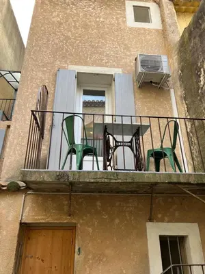 a balcony with two chairs and a table on a balcony at Le Bonheur -studio terrasse centre-ville - in LʼIsle-sur-la-Sorgue