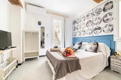 a bedroom with a large bed with black and white faces on the wall at Le Bonheur -studio terrasse centre-ville - in LʼIsle-sur-la-Sorgue