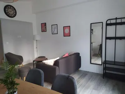 a waiting room with a table and chairs and a mirror at Le Petit Pied à Terre du Luberon in Mérindol