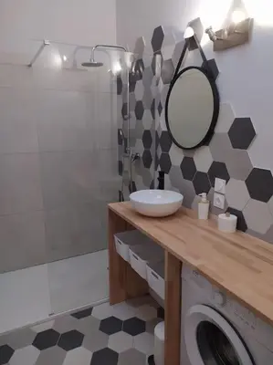 a bathroom with a sink and a mirror and a washing machine at Le Petit Pied à Terre du Luberon in Mérindol