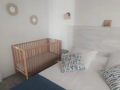 a white bed with a crib in a room at Le Petit Pied à Terre du Luberon in Mérindol